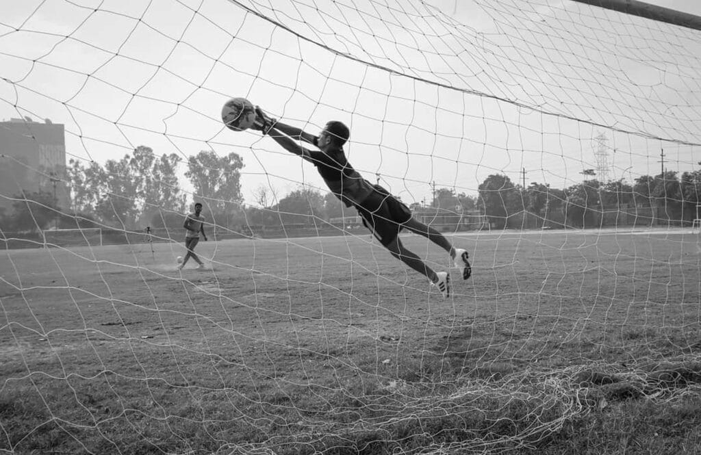 Esta página representa A Defesa Imortal do Goleiro Alcino. um goleiro defendendo penaltis de um cobrador