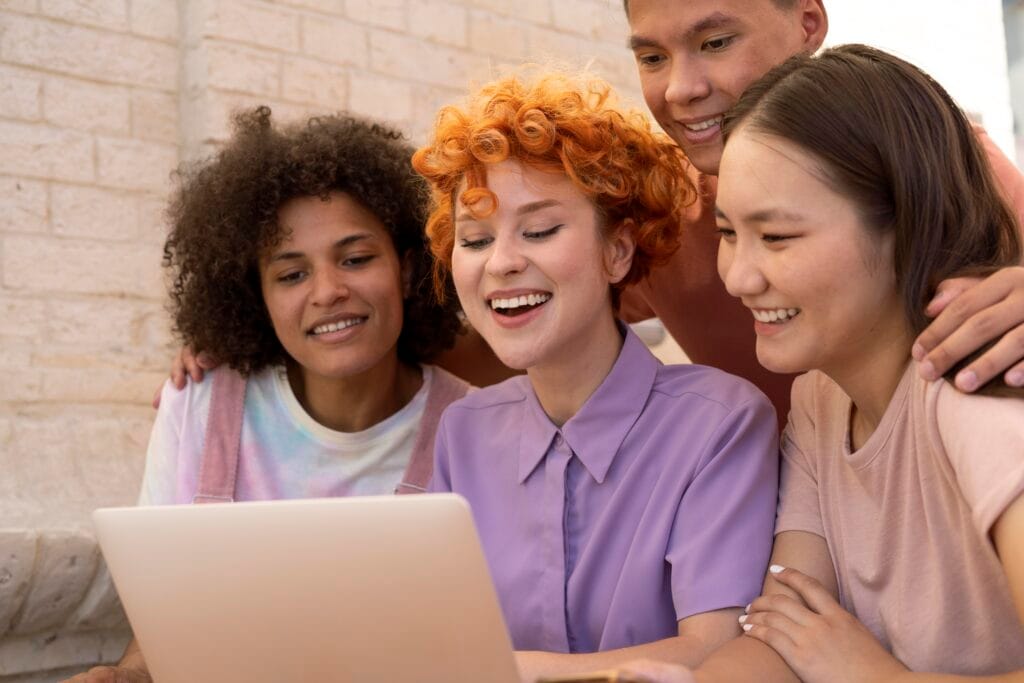 Nesta página mostra 4 jovens geração z utilizando computador. Descubra como compreender a geração z.