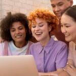 Nesta página mostra 4 jovens geração z utilizando computador. Descubra como compreender a geração z.
